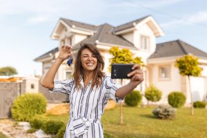 housing market in 2024 selling your home woman with key selfie house